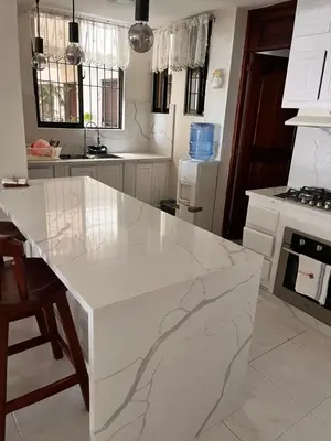 a white kitchen with a large marble counter top at Apartamento amueblado en Villa Olga in Santiago de los Caballeros