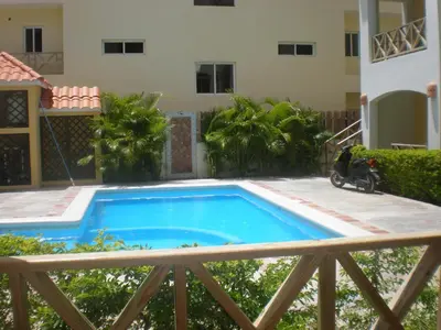 a swimming pool with a scooter parked next to a house at Vanilla House in Bayahibe