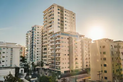 a tall apartment building in a city with buildings at Fully Serviced Apartment at Regatta Living - 2C in Santo Domingo