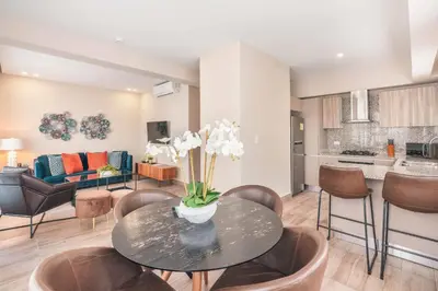 a living room with a table and chairs at Fully Serviced Apartment at Regatta Living - 3B in Santo Domingo
