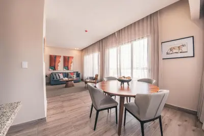 a dining room with a wooden table and chairs at Fully Serviced Apartment at Regatta Living - 3B in Santo Domingo