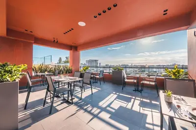 a patio with tables and chairs on a roof at Fully Serviced Apartment at Regatta Living - 9F in Santo Domingo