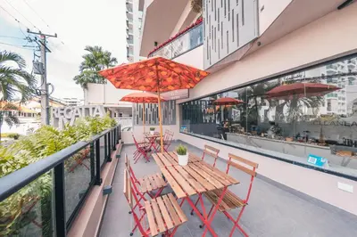 a table and chairs on a balcony with red umbrellas at Fully Serviced Apartment at Regatta Living - 9F in Santo Domingo