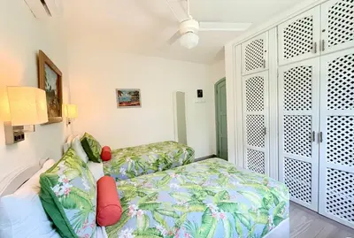a bedroom with a bed and a couch and a fan at La Dolce Vita Beachfront Apt 2 in Las Terrenas
