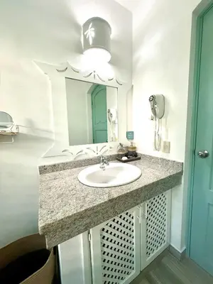a bathroom with a sink and a mirror at La Dolce Vita Beachfront Apt 2 in Las Terrenas