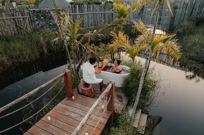 two people sitting in a boat on a dock at Green Land Bubble Glamping in Cabarete