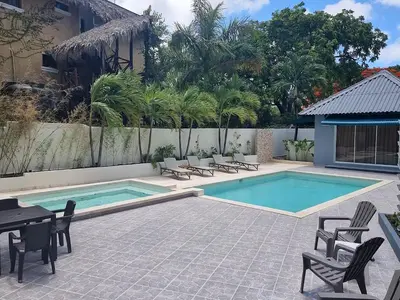 a swimming pool with chairs and a table next to a building at Hotel Sea Breeze Sosua in Sosúa