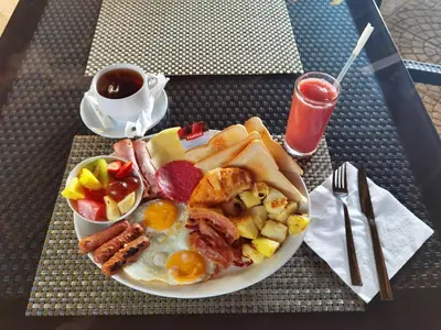a plate of breakfast food with eggs bacon and toast at Hotel Sea Breeze Sosua in Sosúa