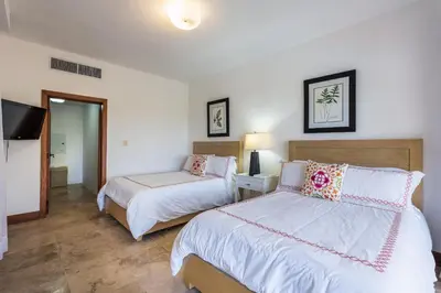 a bedroom with two beds and a flat screen tv at The Greatest 3BR Villa at Puerto Bahia in Los Grini