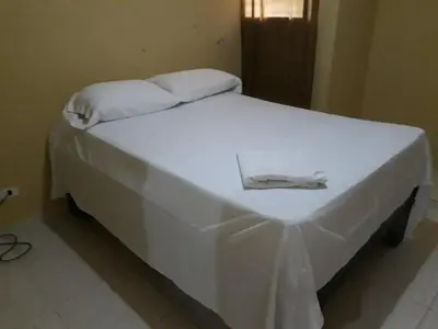a white bed with a white blanket on it at Apartahotel Next Nivel - Queen room with Ac in Punta Cana