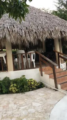 a hut with chairs and a thatched roof at VILLA CAMPESTRE EN LOMAS LINDA in Villa Altagracia