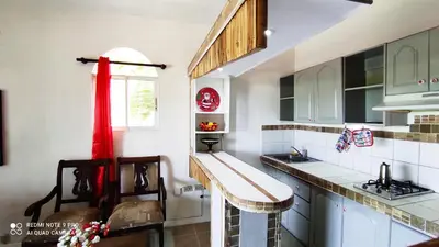 a kitchen with white cabinets and a red curtain at Private Study Punta Cana in Punta Cana