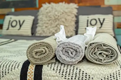 a bed with towels and pillows on it at Studio Apartment Center of Sosua Remote Worker Space Fast WiFi in Sosúa