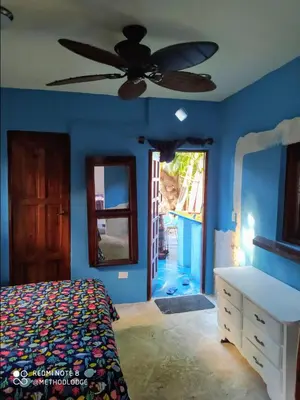 a bedroom with blue walls and a ceiling fan at Method Living Tropical Edition 50024 in Cabarete