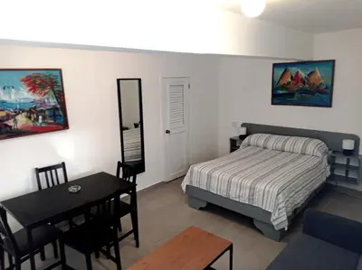 a bedroom with a bed and a table and a dining room at Hotel Casa Coco in Boca Chica