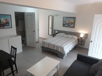 a bedroom with a bed and a living room at Hotel Casa Coco in Boca Chica