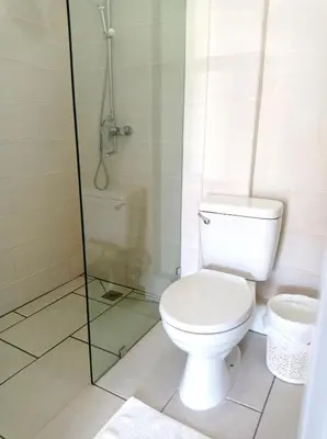 a bathroom with a toilet and a glass shower at Hotel Casa Coco in Boca Chica