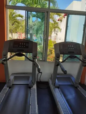 a gym with two treadying machines and a window at Cerro Altos jardin 809-488-8618 in Santiago de los Caballeros