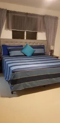 a blue bed with blue pillows in a bedroom at Cerro Altos jardin 809-488-8618 in Santiago de los Caballeros