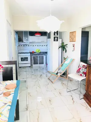 a living room with a tile floor and a table and chairs at En el corazón de la romana con a/c, wifi, luz y gas incluido. in La Romana