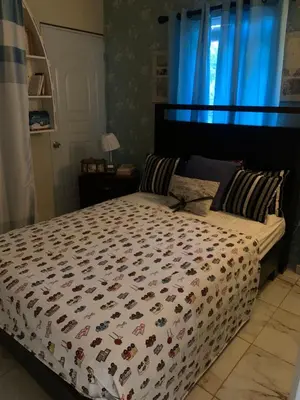 a bedroom with a bed with a comforter on it at En el corazón de la romana con a/c, wifi, luz y gas incluido. in La Romana