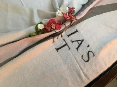a flower arrangement on a bed with the word iv at En el corazón de la romana con a/c, wifi, luz y gas incluido. in La Romana