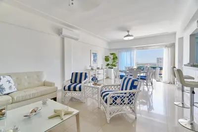 a living room with a couch and a table with chairs at Sunset View 2BR Apartamento Juan Dolio Las Velas in Juan Dolio