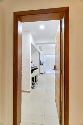 an open door leading into a hallway with a white tile floor at Sunset View 2BR Apartamento Juan Dolio Las Velas in Juan Dolio