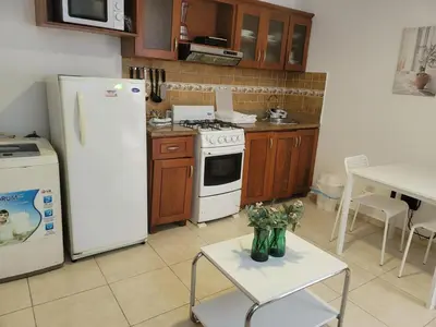 a kitchen with a white refrigerator and a table with flowers at small apartment in Santo Domingo