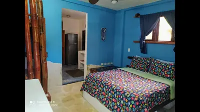 a bedroom with a bed and a blue wall at Method Living Tropical Edition in Cabarete