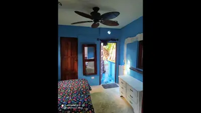 a bedroom with blue walls and a ceiling fan at Method Living Tropical Edition in Cabarete