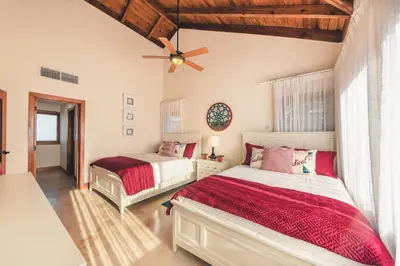 a bedroom with two beds and a ceiling fan at Luxurious Villa at Puerto Bahia with Great Views in Los Grini