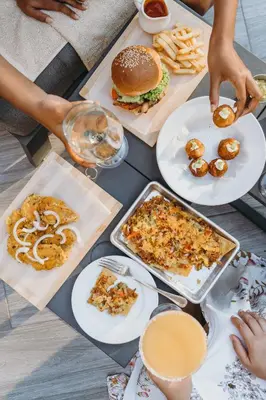 a group of people sitting around a table with food at Regatta Living Hotel By Mint in Santo Domingo