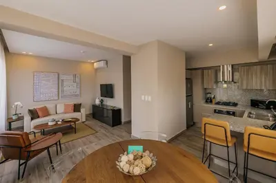 a living room with a table and a kitchen at Regatta Living Hotel By Mint in Santo Domingo