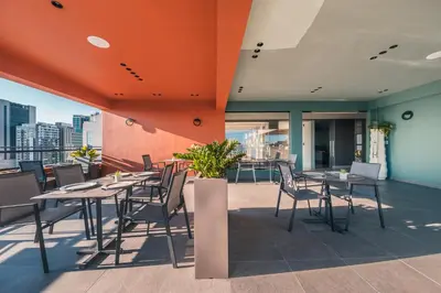 a restaurant with tables and chairs on a balcony at Regatta Living Hotel By Mint in Santo Domingo