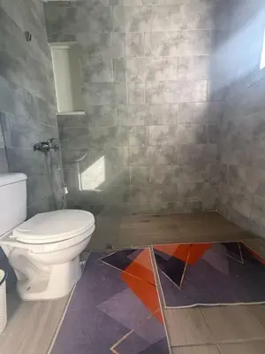 a bathroom with a toilet and a tile wall at Hotel Sol Azul in La Romana
