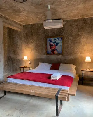 a bedroom with a large bed with a red blanket at Taino Beach Lofts in El Valle
