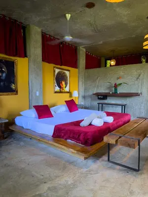 a bedroom with a large bed with red pillows at Taino Beach Lofts in El Valle