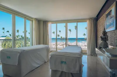 a bedroom with a bed and a sink and a view of the ocean at JOIA Bavaro by Iberostar - Adults Only All Inclusive Resort in Punta Cana