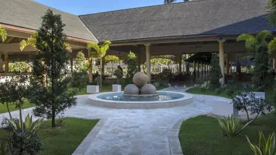 a courtyard with a fountain in front of a building at Iberostar Waves Punta Cana - All Inclusive in Punta Cana
