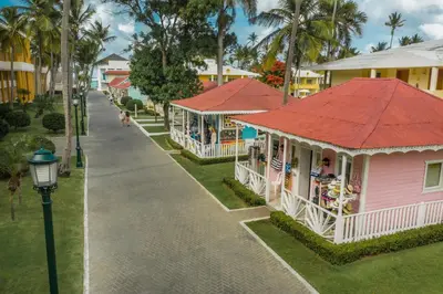 a pink building with a red roof next to a street at Iberostar Waves Punta Cana - All Inclusive in Punta Cana