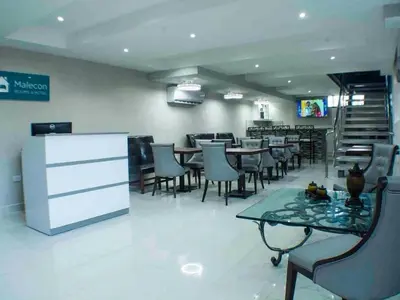 a dining room with tables and chairs in a restaurant at Malecon Cozy Private Room in Santo Domingo