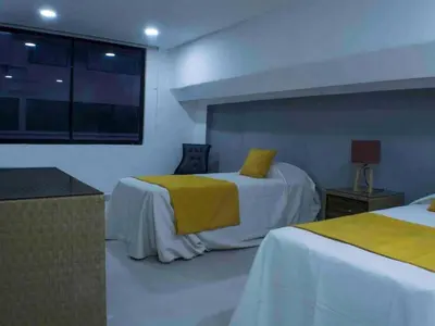 a hotel room with two beds and a window at Malecon Cozy Private Room in Santo Domingo