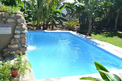 a large blue swimming pool in a yard at ECOVILLA CORAL GARDEN in Baoruco