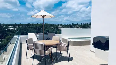 a table with chairs and an umbrella on a balcony at Hermoso Penthouse a solo pasos de la Playa in Punta Cana
