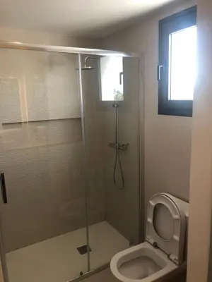 a bathroom with a glass shower with a toilet at Hermoso Penthouse a solo pasos de la Playa in Punta Cana