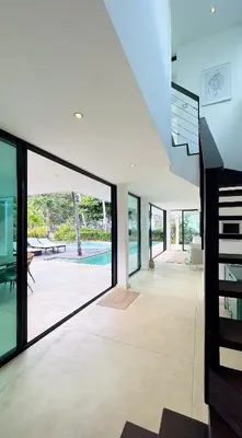 an open living room with glass doors and a staircase at Villa Isha - modernist hideaway at Cap Bonita in Las Terrenas