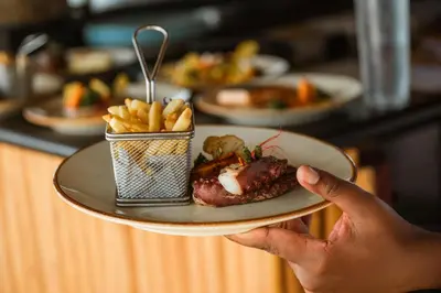 a person holding a plate of food and french fries at Iberostar Selection Bavaro Suites - All Inclusive in Punta Cana