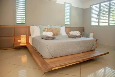 a bedroom with a large bed with a wooden frame at Tropical Penthouse in the Heart of Las Terrenas! in Las Terrenas