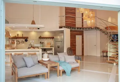a living room with two chairs and a table and a staircase at Tropical Penthouse in the Heart of Las Terrenas! in Las Terrenas